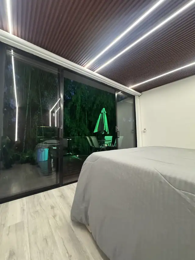 La cama king con ventanal de piso a techo que abre al deck.