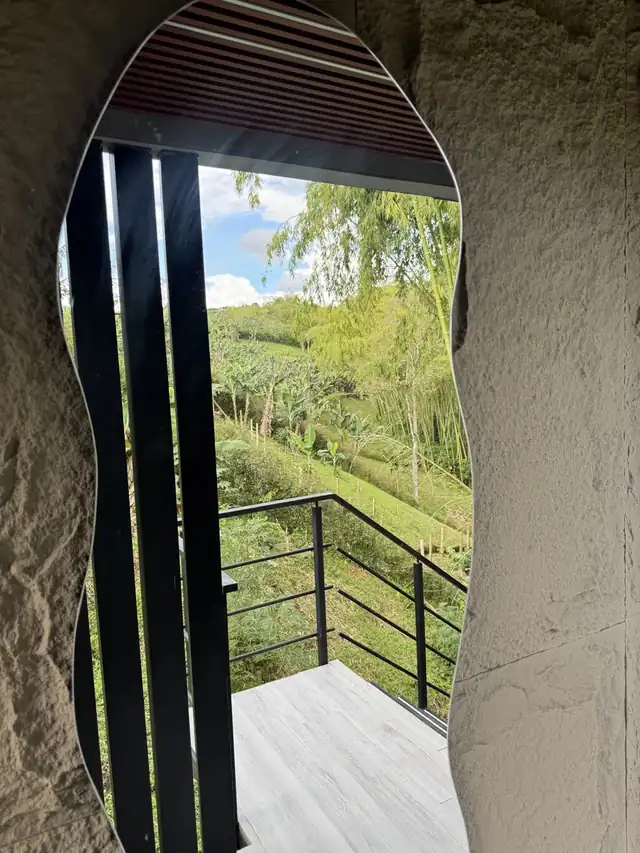 La ventana curva en la piedra enmarcando las colinas de día.