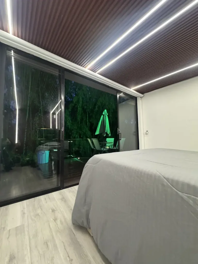 La cama king con ventanal de piso a techo que abre al deck.