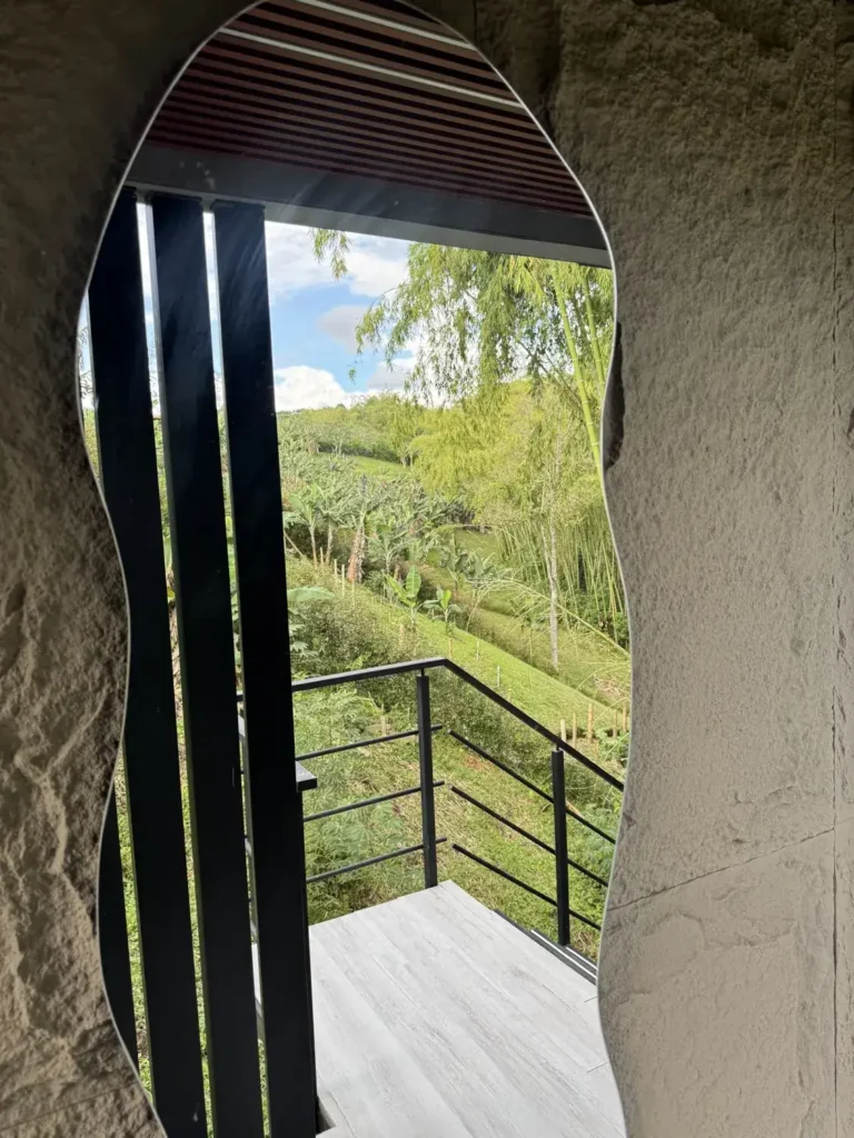 La ventana curva en la piedra enmarcando las colinas de día.